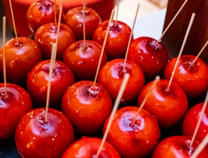 Eine Gruppe roter Äpfel mit Zahnstochern darauf.