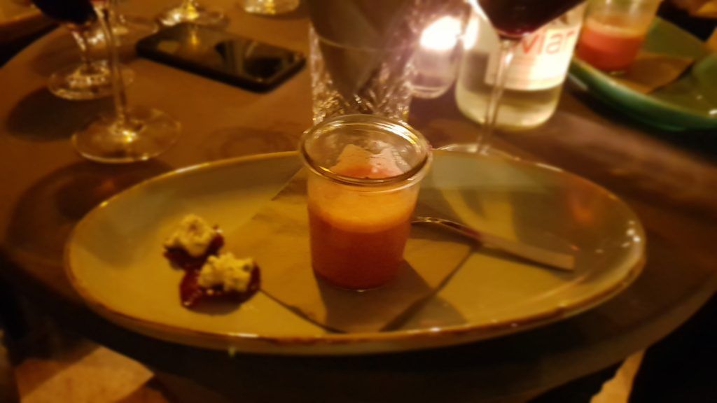 Ein Glas mit einem Dessert steht auf einem Tisch.