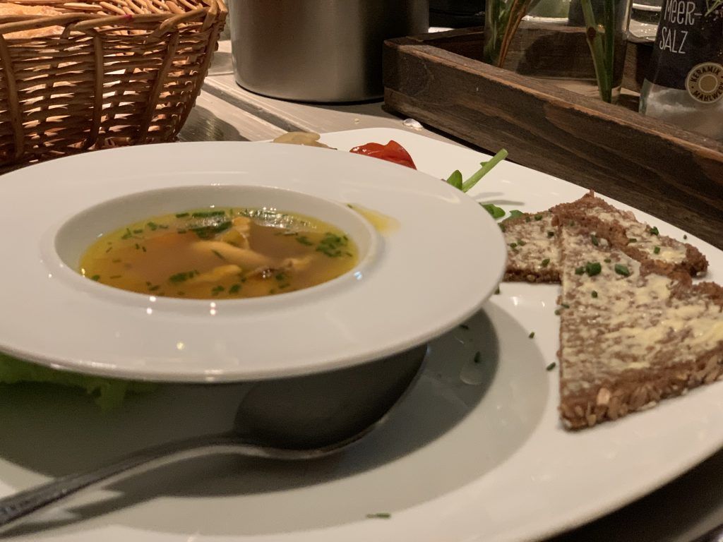 Eine Schüssel Suppe und Brot auf einem Teller.