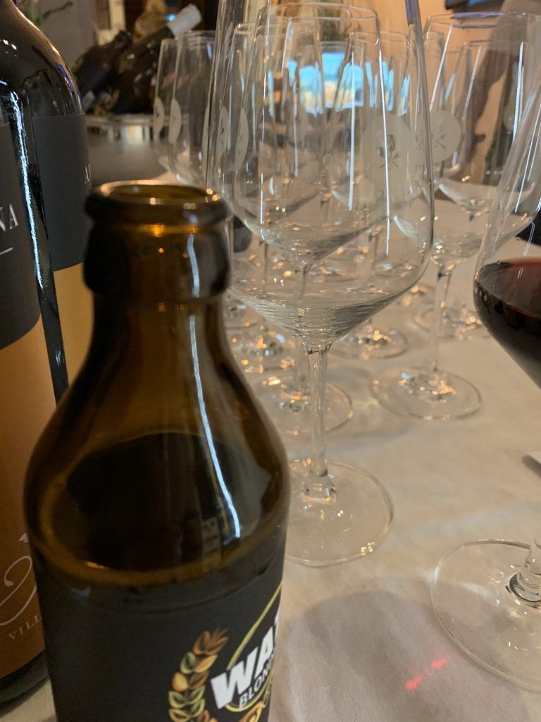 Eine Flasche Wein auf einem Tisch neben einem Glas Wein.