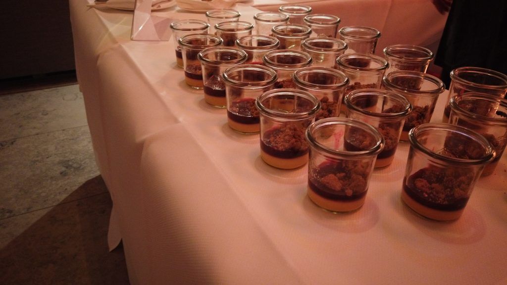 Ein Tisch voller Gläser mit Desserts auf einem Tisch.
