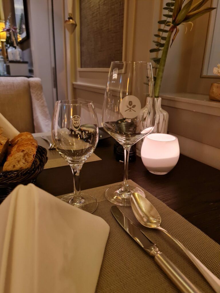 Ein gedeckter Tisch mit Weingläsern und einer Kerze.