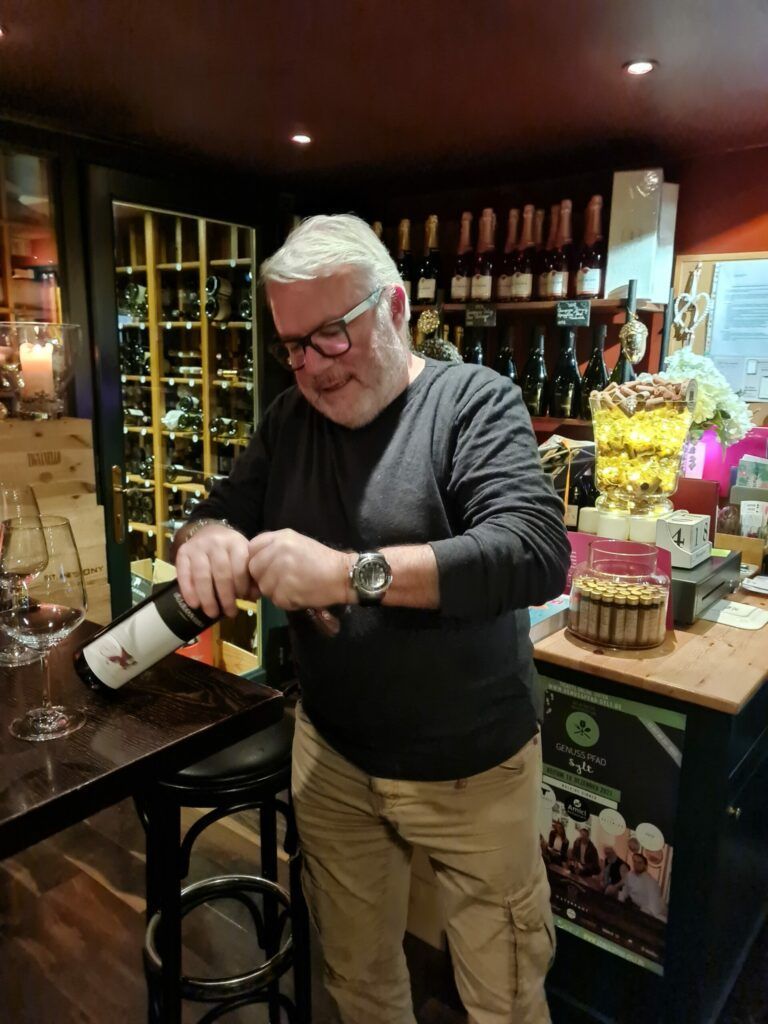 Ein Mann gießt Wein in ein Glas.