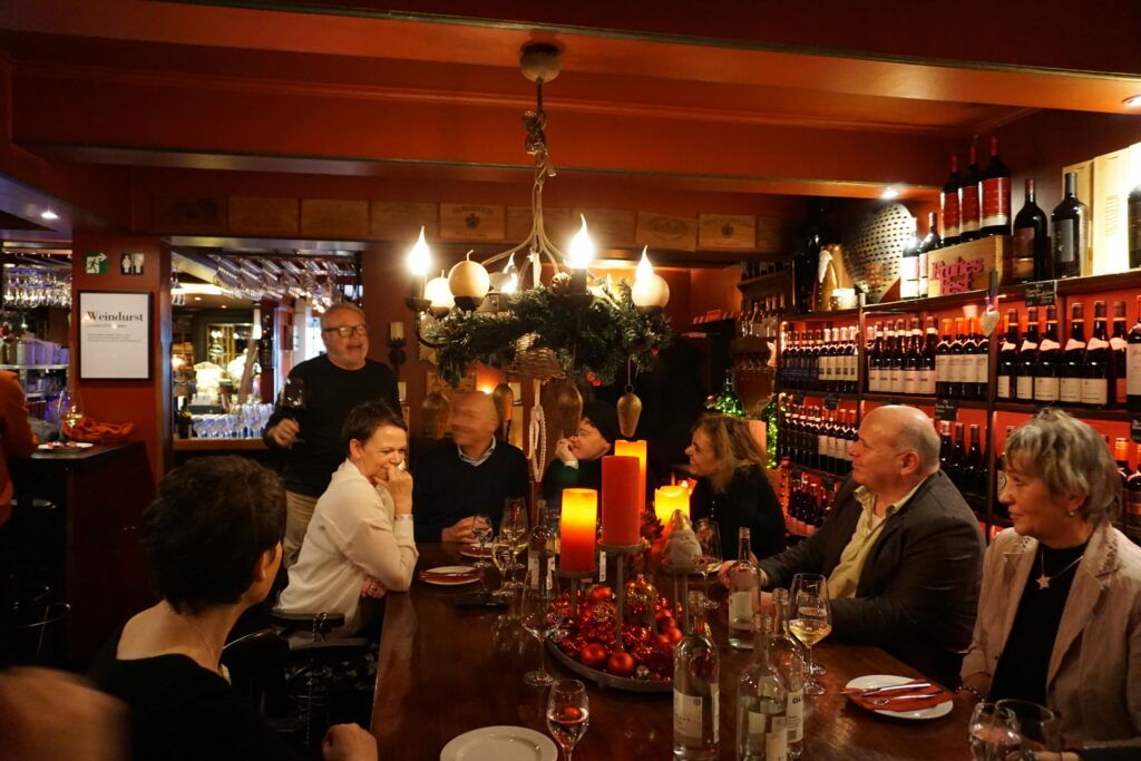 Eine Gruppe von Menschen sitzt an einem Tisch in einer Weinbar.