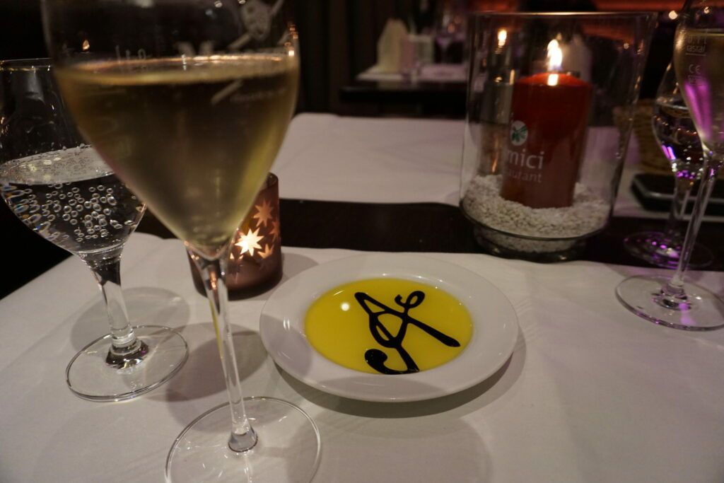 Ein Glas Champagner auf einem Tisch neben einem Teller.