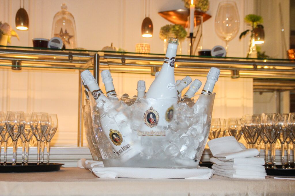 Ein Eiskübel gefüllt mit Sektflaschen und Gläsern.