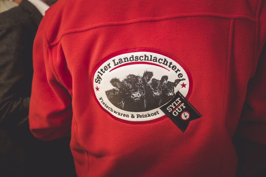 Die Rückseite einer roten Jacke mit einem Logo darauf.