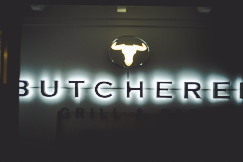 Butcher's Grill und Bar sind mit einer Leuchtreklame beleuchtet.