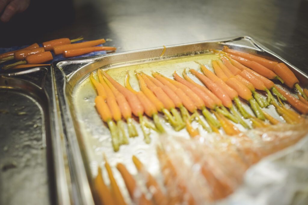 Ein Tablett mit Karotten, die in einer Küche gekocht werden.