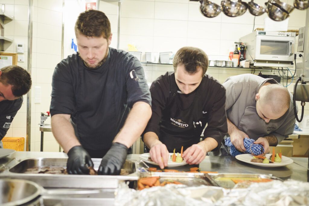 Eine Gruppe von Männern bereitet in einer Küche Essen zu.