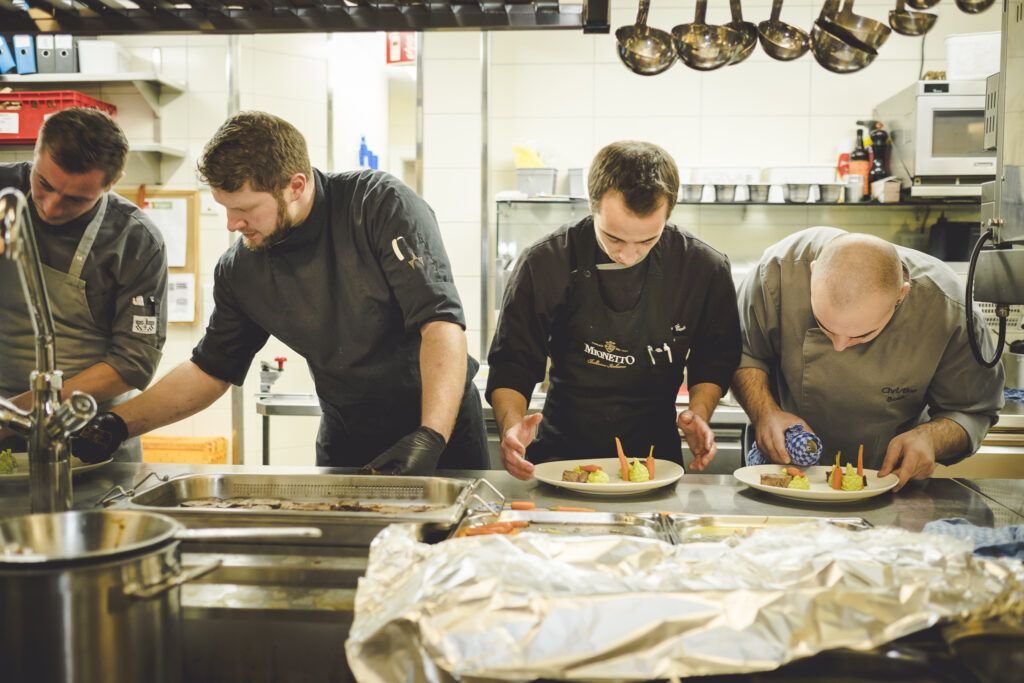 Eine Gruppe von Männern bereitet in einer Küche Essen zu.