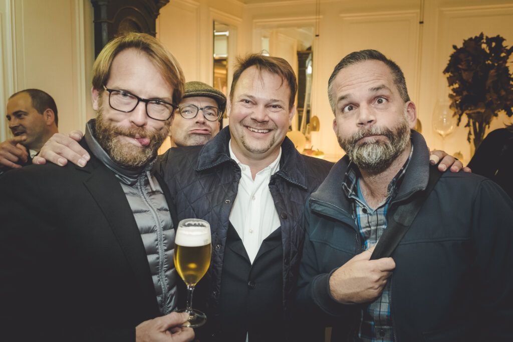 Drei Männer posieren für ein Foto auf einer Party.