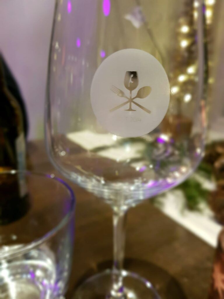 Ein Weinglas mit einem Logo darauf.