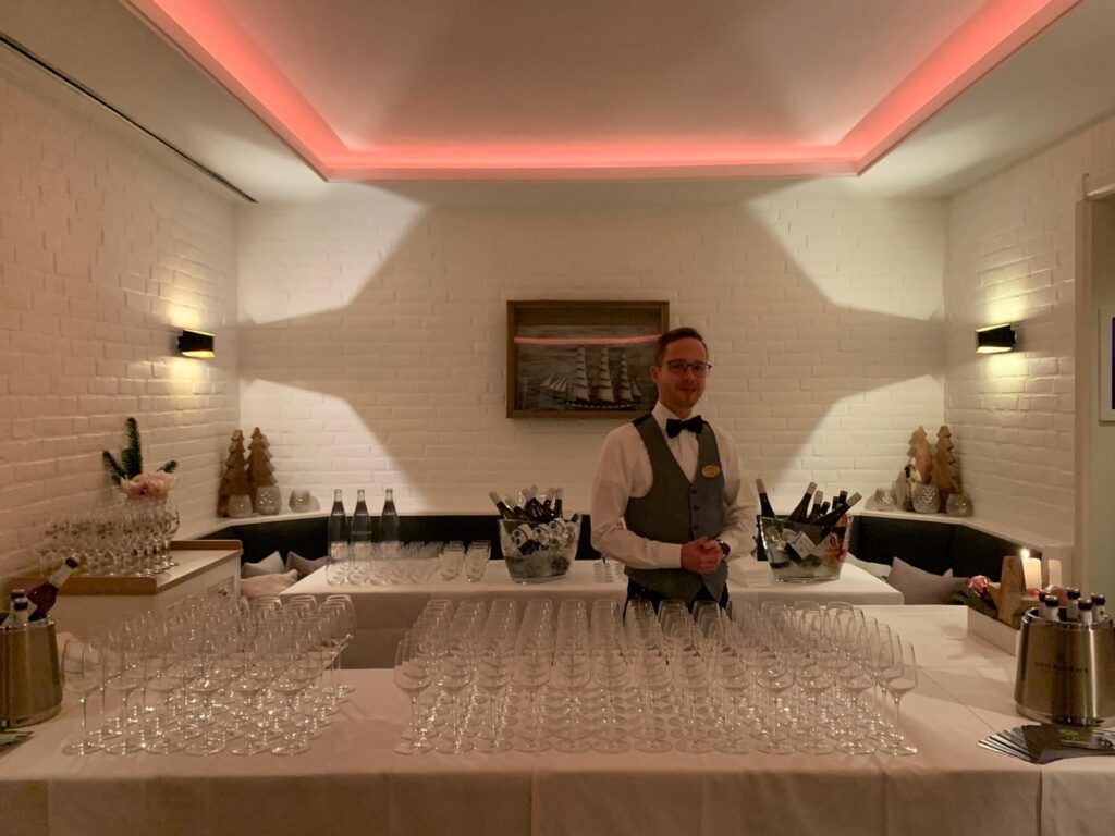 Ein Mann steht vor einem Tisch voller Weingläser.