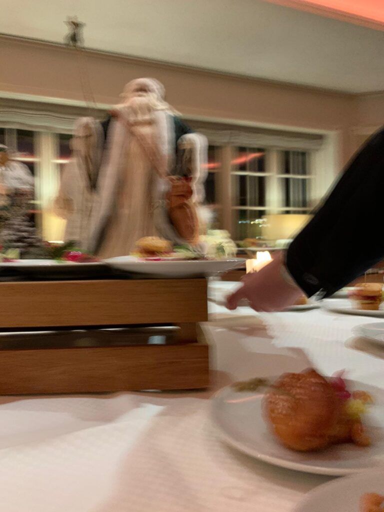 Ein Mann zeigt auf einen Teller mit Essen auf einem Tisch.