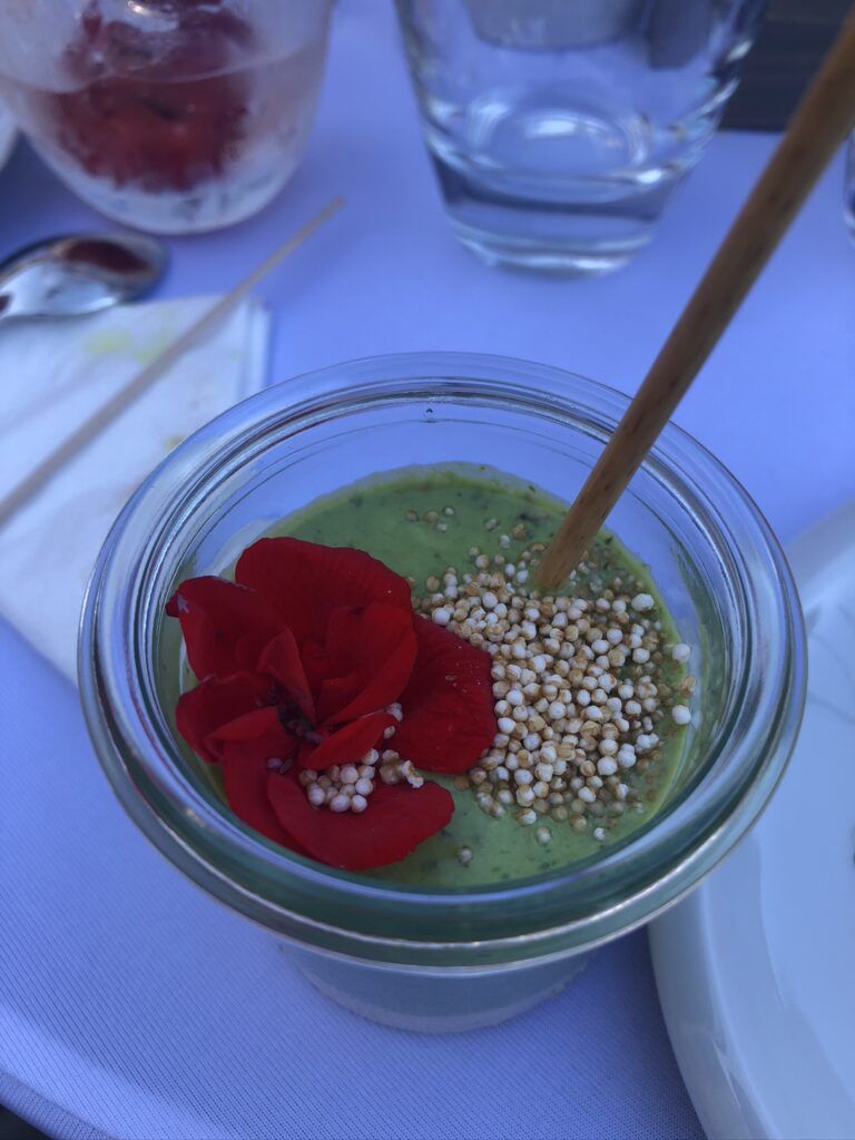 Ein Glas grüner Smoothie mit einer Blume darin.