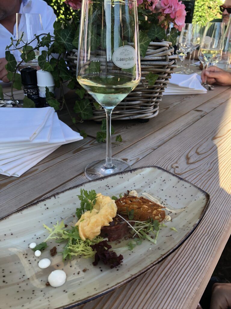 Ein Teller mit Essen und einem Glas Wein darauf.