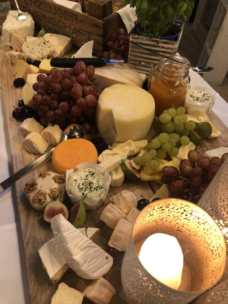 Eine Platte mit Käse und Obst auf einem Tisch.
