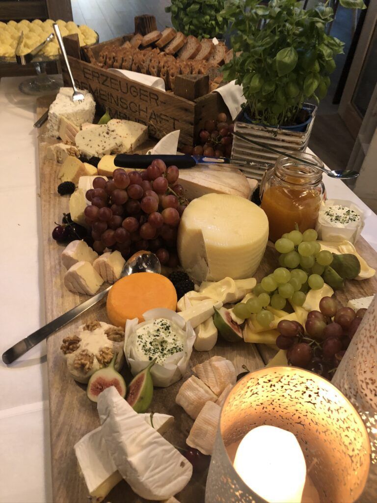 Eine Platte mit Käse und Obst auf einem Tisch.