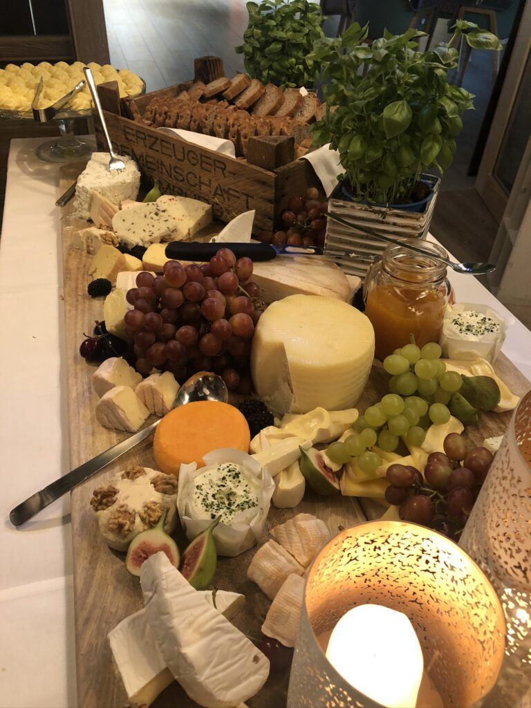 Eine große Platte mit Käse und Obst auf einem Tisch.