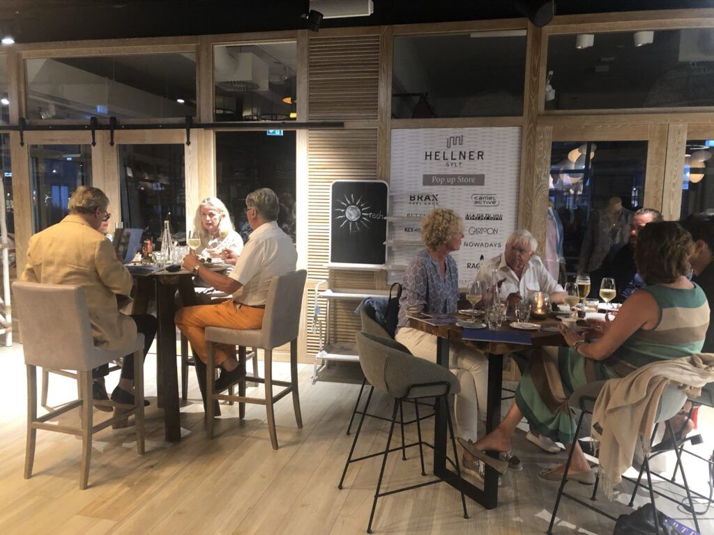 Eine Gruppe von Menschen sitzt an Tischen in einem Restaurant.
