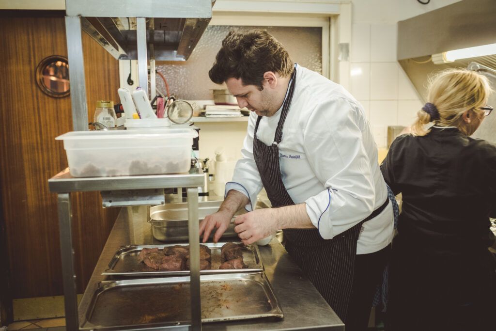 Ein Mann bereitet Essen in einer Küche zu.