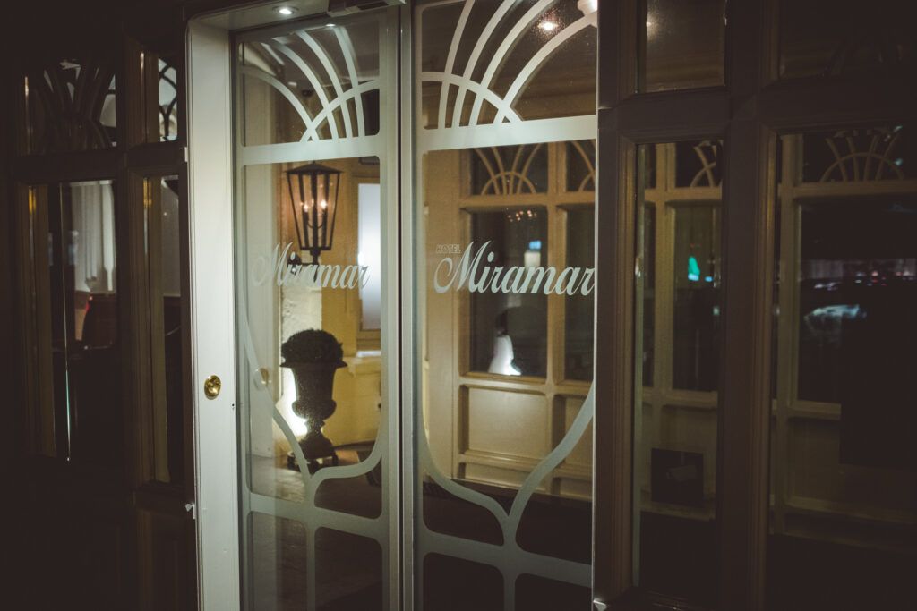 Nachts eine Glastür mit Schrift Miramar darauf.