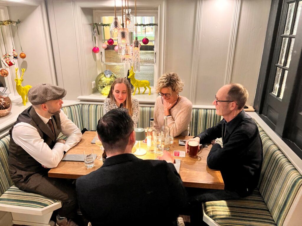 Eine Gruppe von Menschen sitzt in einem Restaurant um einen Tisch.