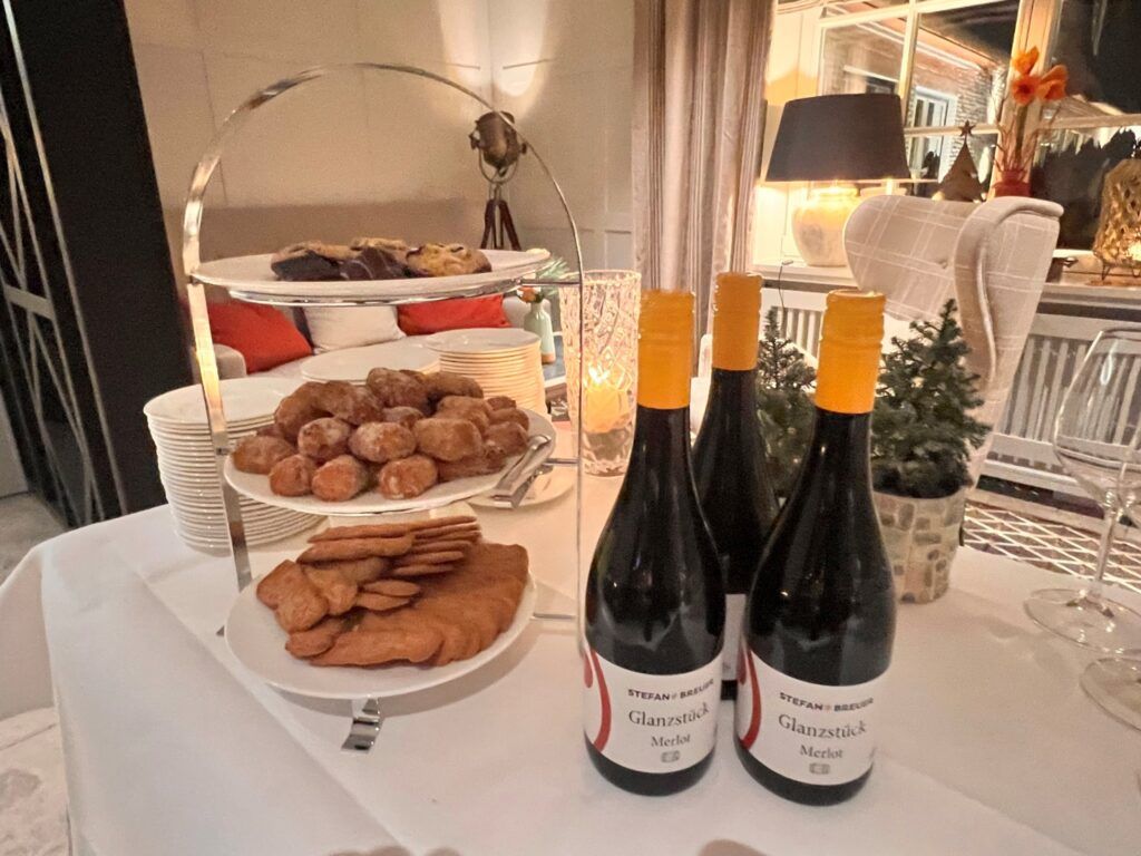 Drei Flaschen Wein und Kekse auf einem Tisch.