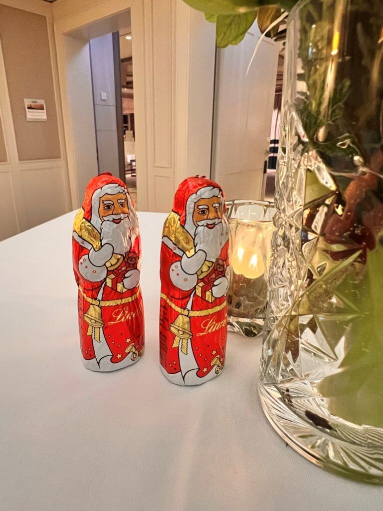 Zwei Weihnachtsmannfiguren auf einem Tisch.